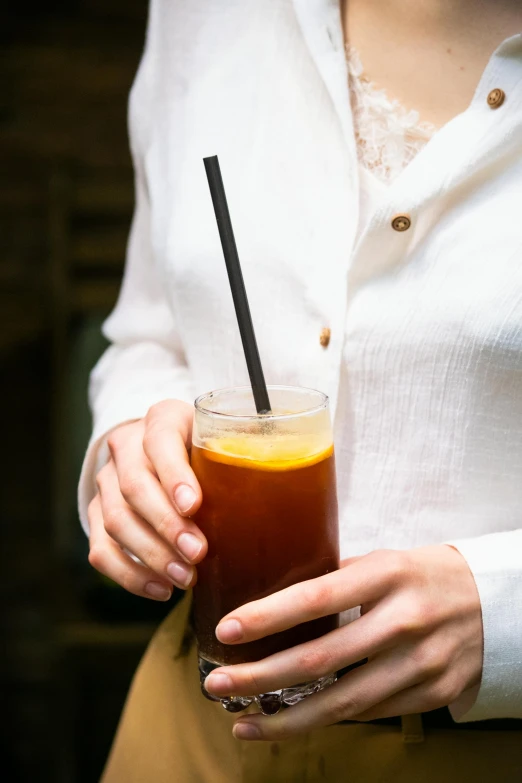 a person holding a drink with a straw in it