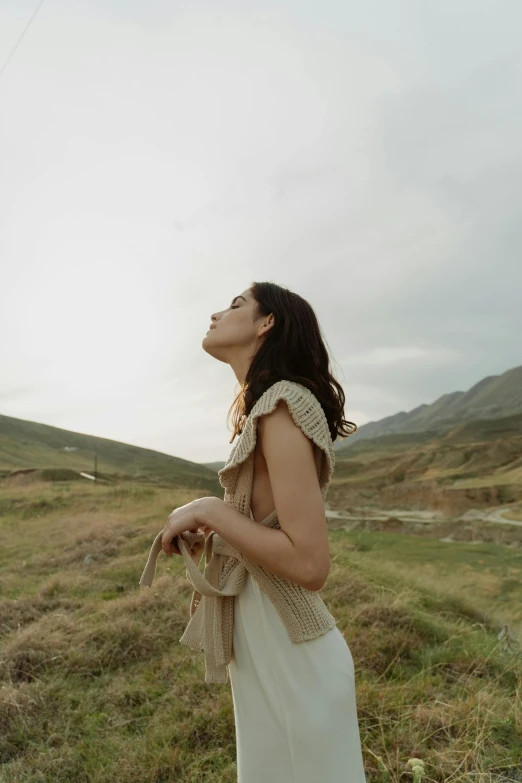 a beautiful young woman in white dress looking up at soing