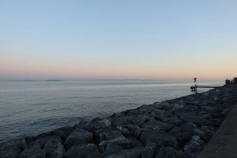 a person standing on top of a rocky shore line