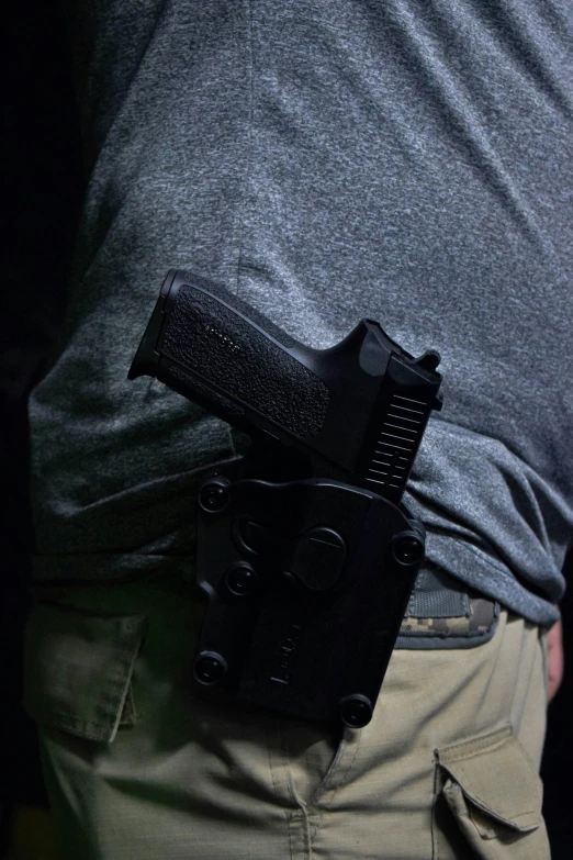 a man holding onto a belt holster with his hands in the back pocket