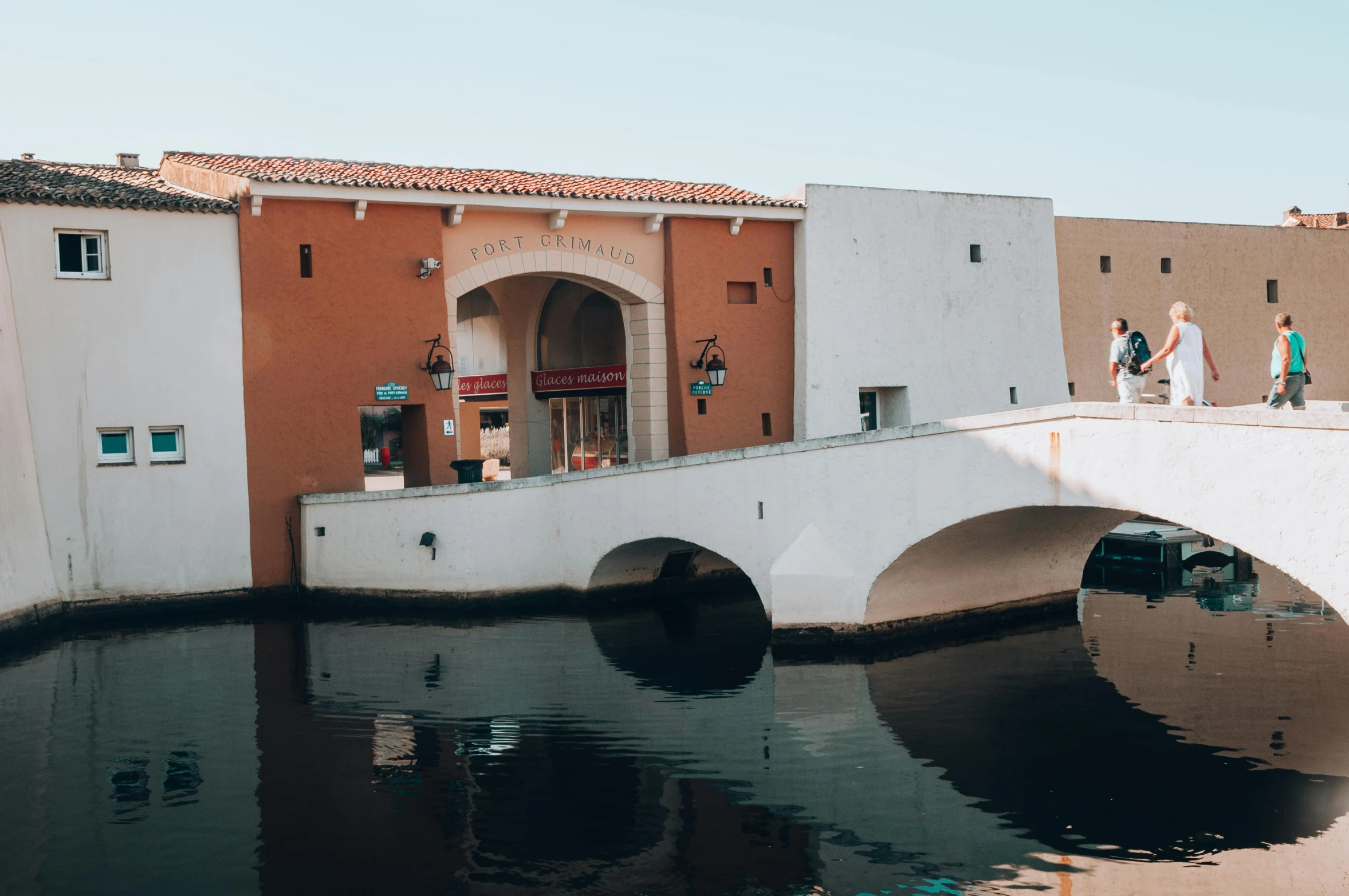 a bridge over some water and people standing on the other side