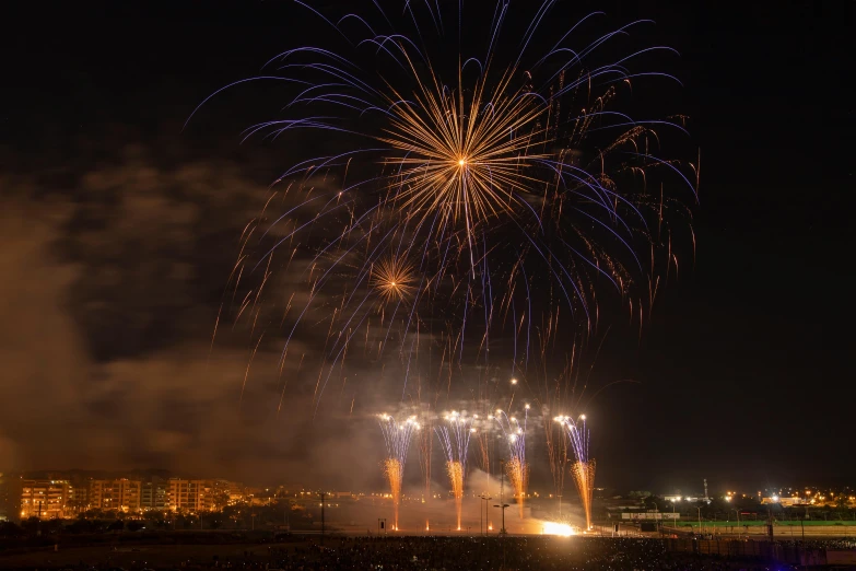 a large firework display with bright lights in the night sky