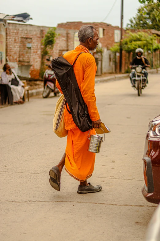 a man walking down the street carrying a bag and a backpack