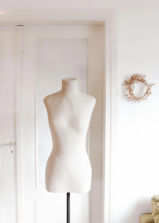 a white mannequin in front of a window