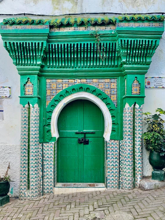 an ornate doorway to an old green door on the side of a building