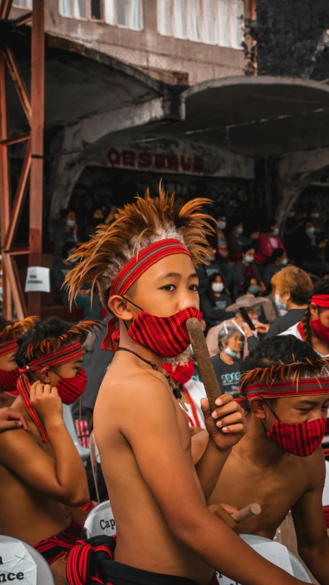 the child is wearing native garb and has his head held back