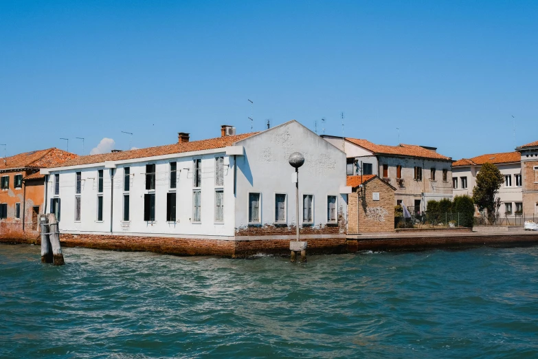 two white houses next to water and a blue sky