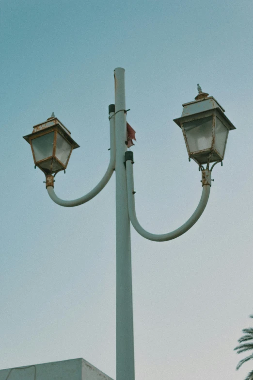 a pair of lamps and a street light with a blue sky in the background