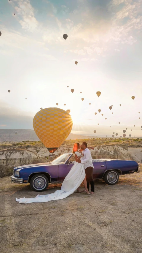 a man and a woman standing in front of a purple car