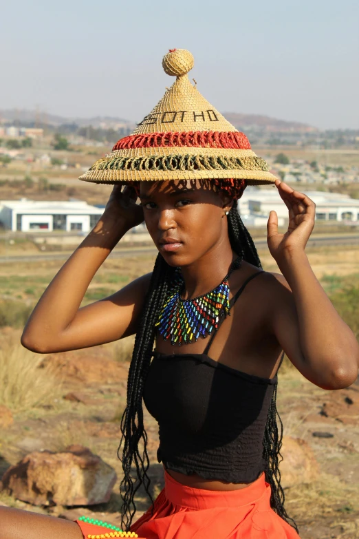 a woman with a straw hat sitting on the ground