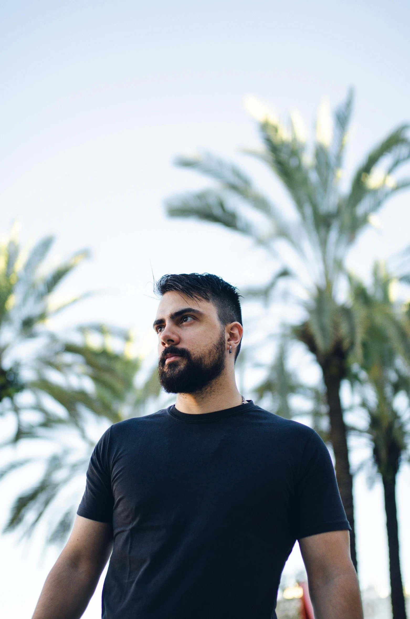 a man is standing near some palm trees