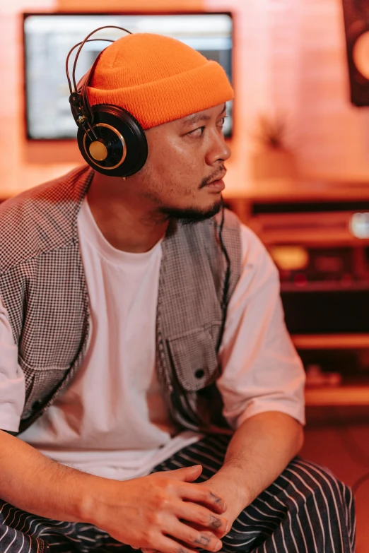 a man sitting down wearing headphones looking up at the sky