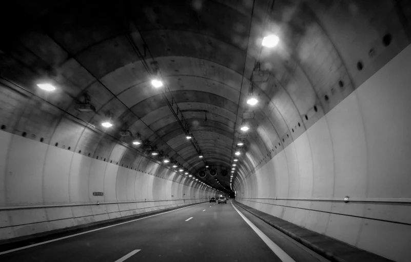 an empty tunnel with lights shining in the ceiling