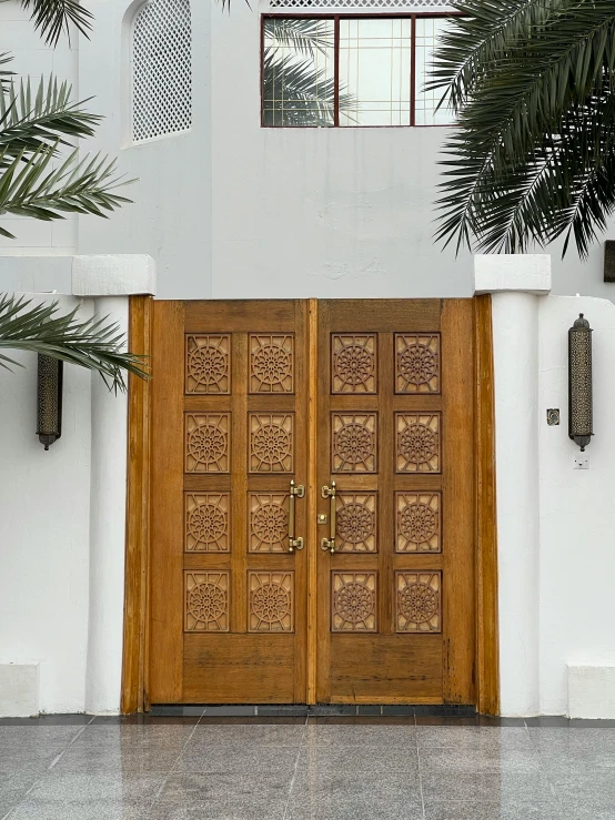 two brown double doors sitting in the corner of a building