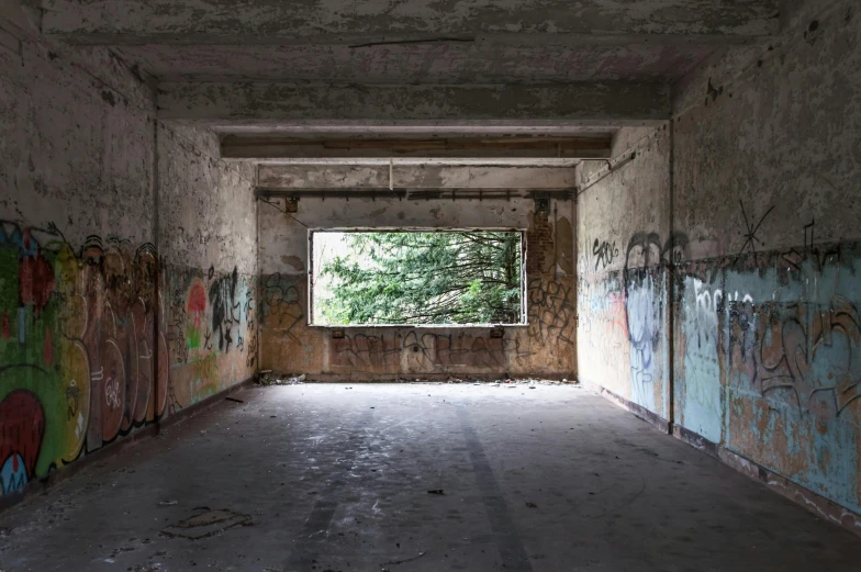 the hallway of a building with graffiti and no one is in it