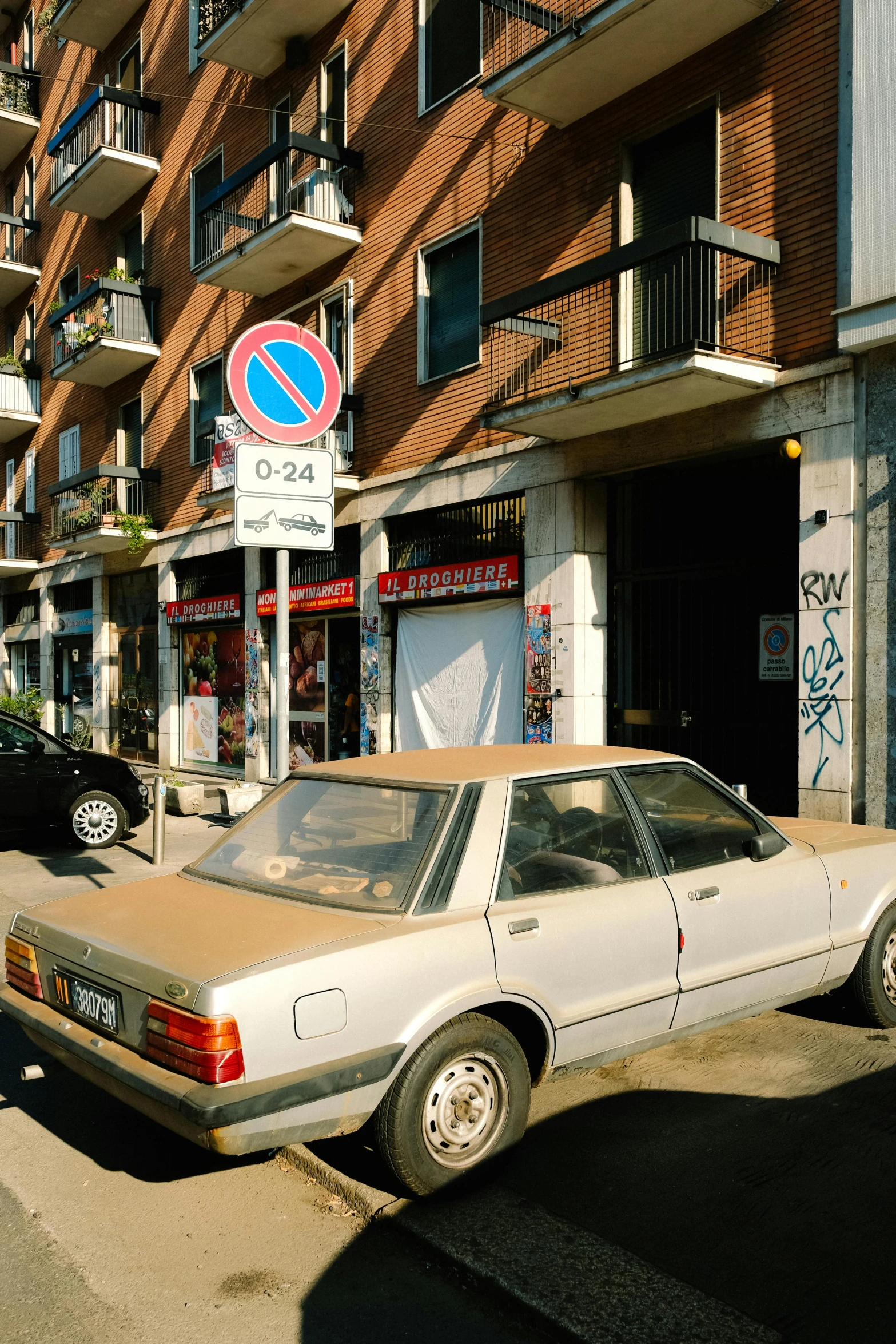 an old car parked on a street with graffiti