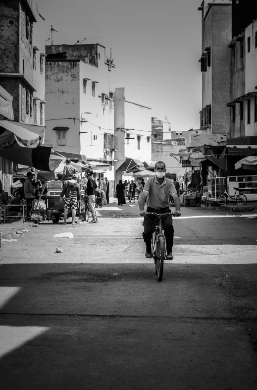 a man rides his bike through an open air market