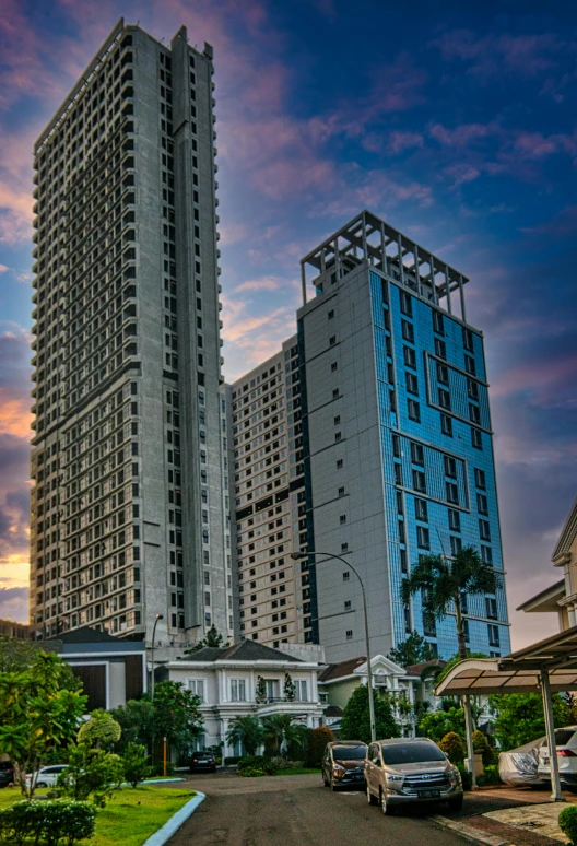 a cityscape of two very tall buildings in front of a cloudy sky