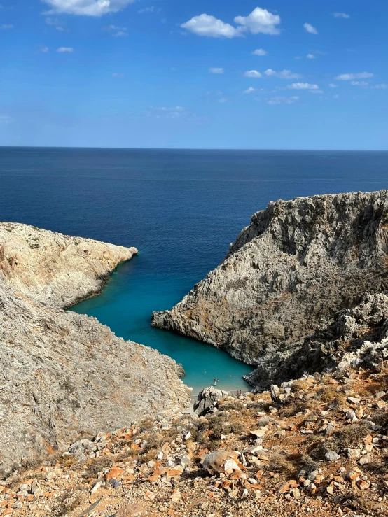 water with no people in it next to a large rocky cliff