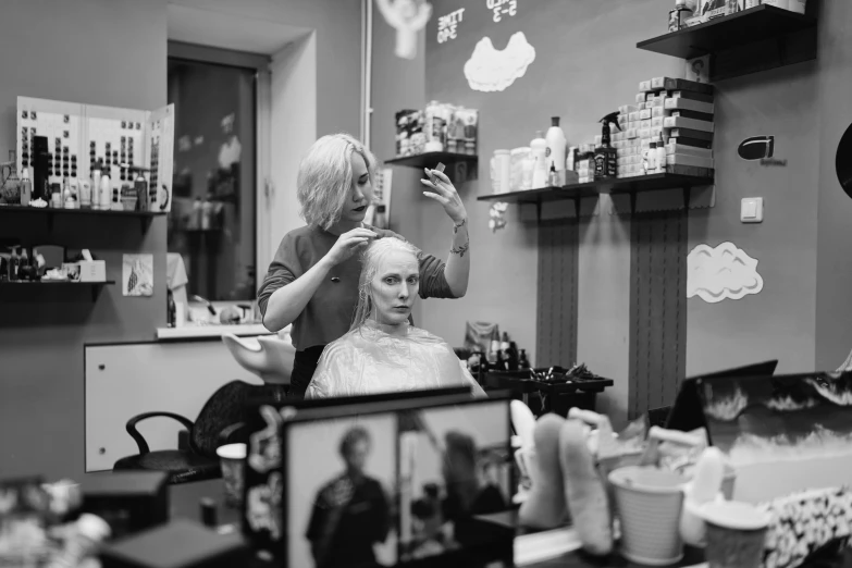 a woman sitting in a barber shop looking at a person