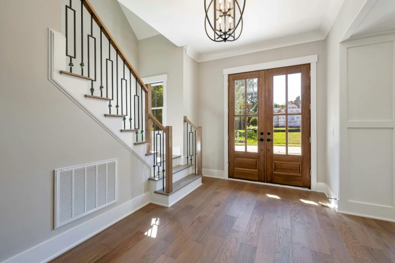 the entry of a large house with two double doors and staircase