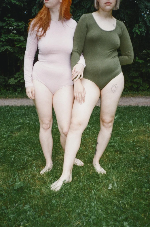 two young women pose on the grass for a pograph