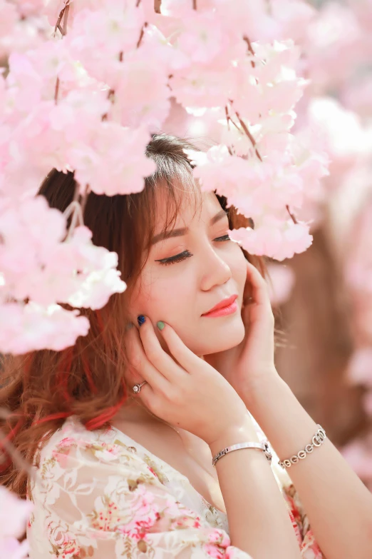 an asian woman with blue eyes wearing a pink flower crown