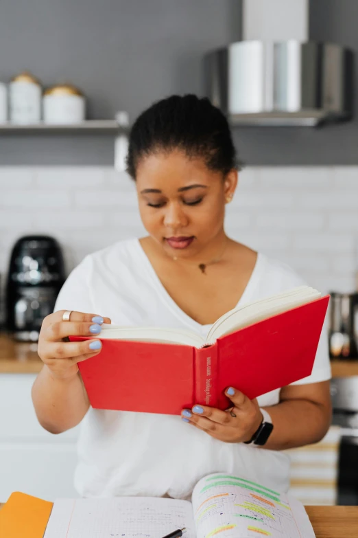 a woman in a white shirt is reading a book