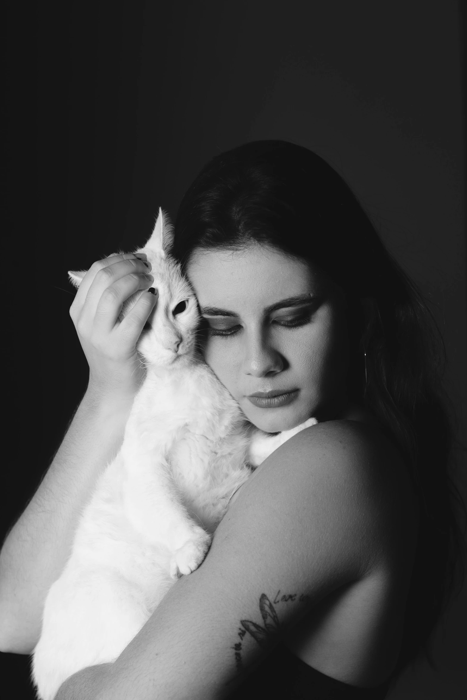 a woman holding a white cat in her arms