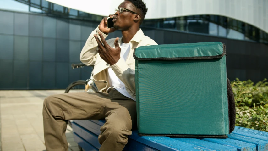 a man on the phone sitting on a blue bench