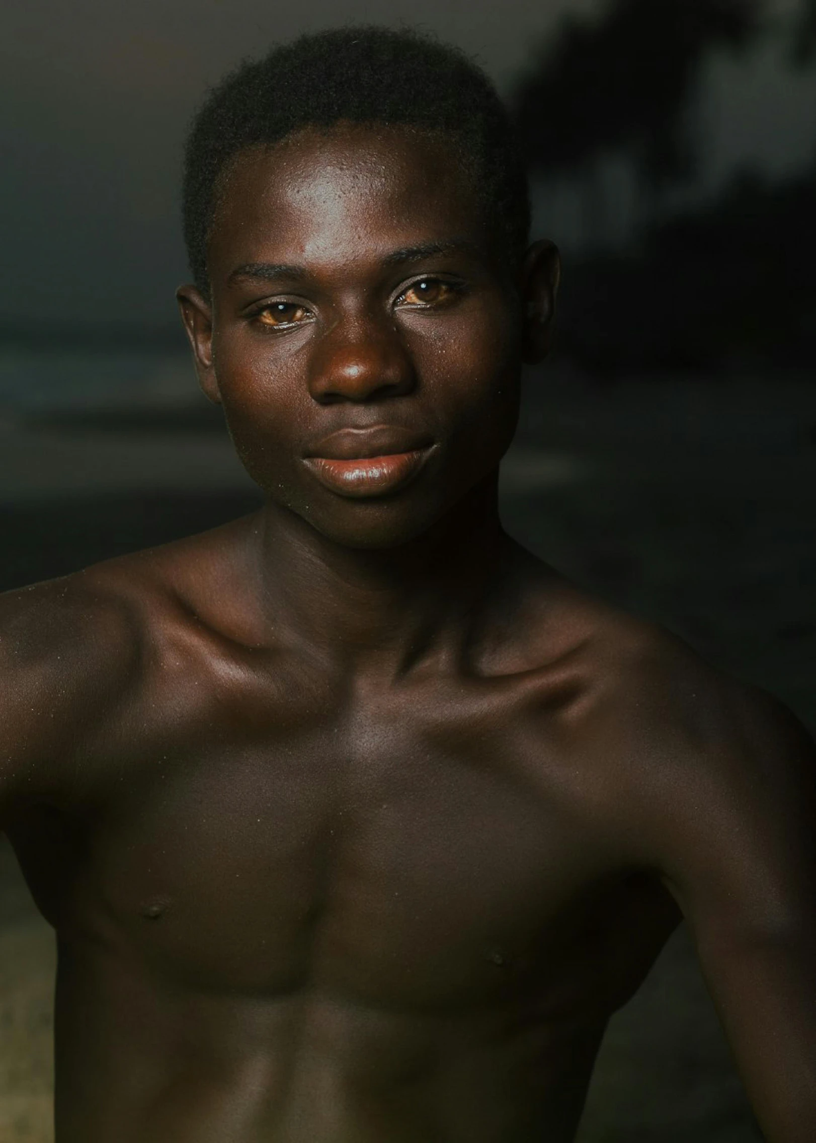 an african man in his dark skin poses with his shirt down