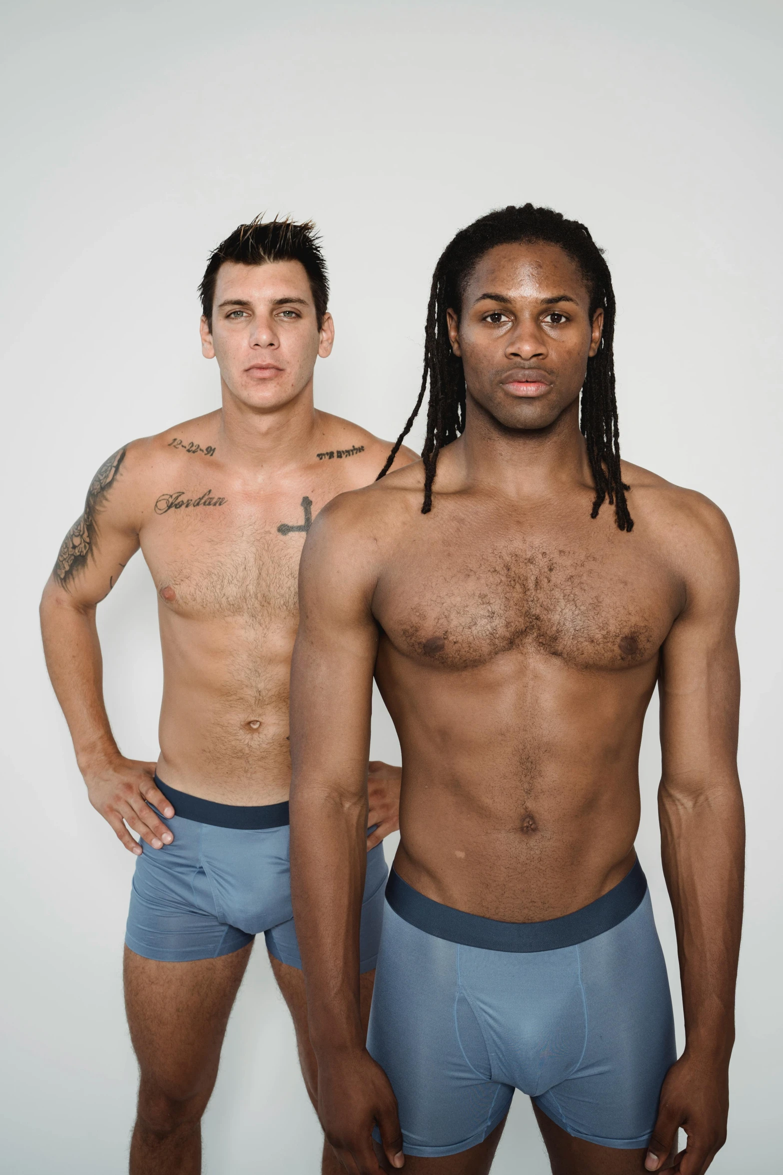 two men that are standing up and wearing underwear