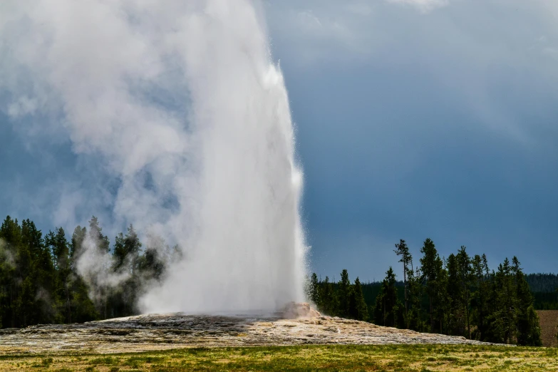 geyser spewing out water from a large cliff