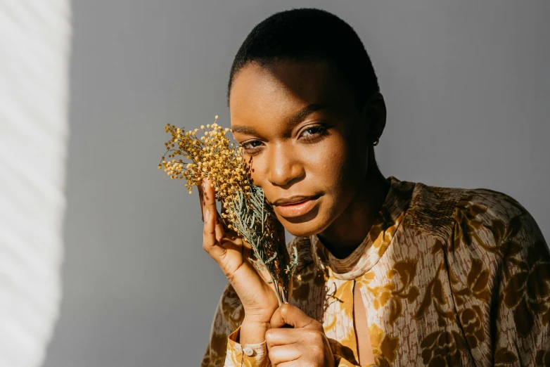 a woman holding flowers in her hands and looking into the camera