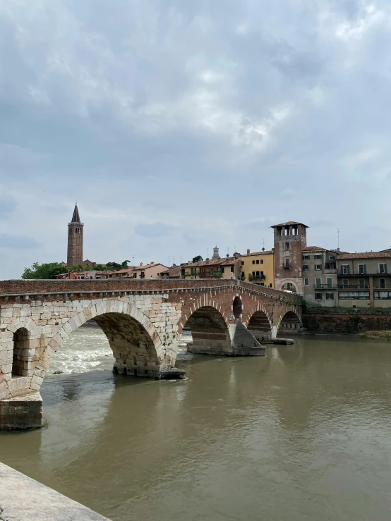 the old bridge is spanning across a wide river