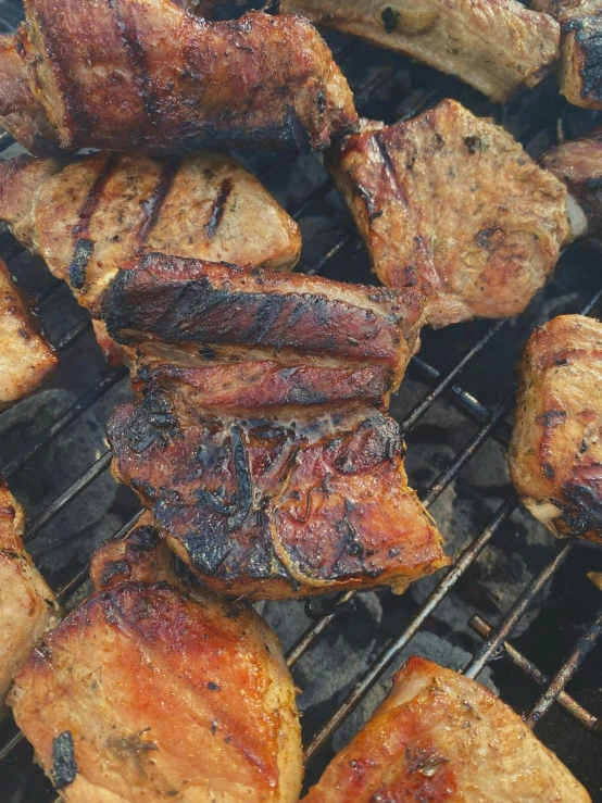 some meat and food on a grill with some sticks