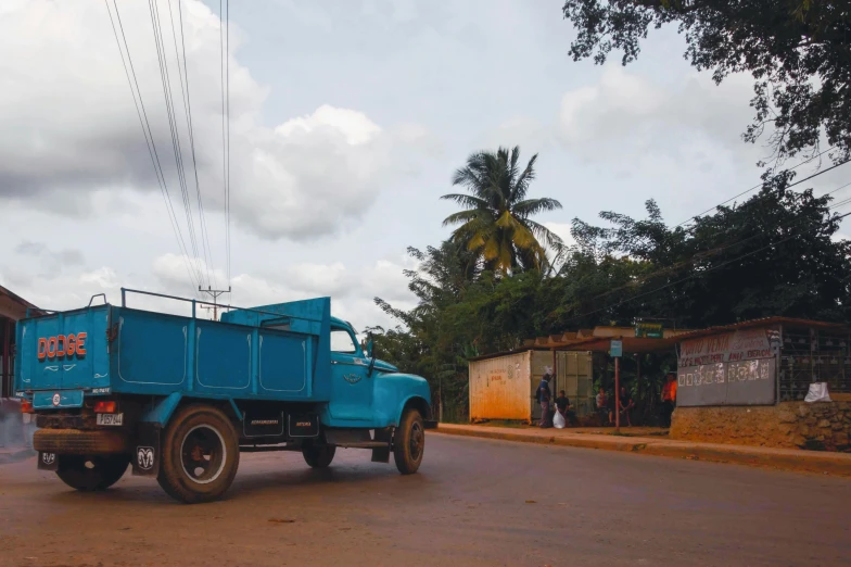 a blue truck is traveling down the street