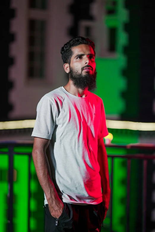 a man stands next to a green and red light