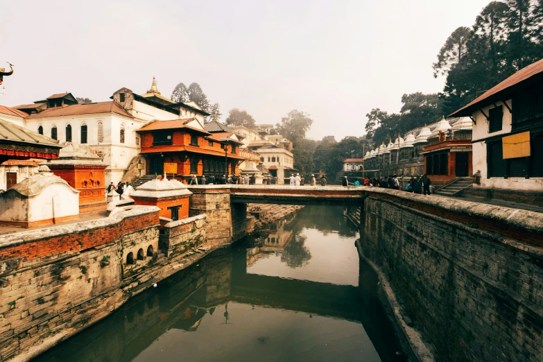 the river is running through a town with wooden buildings