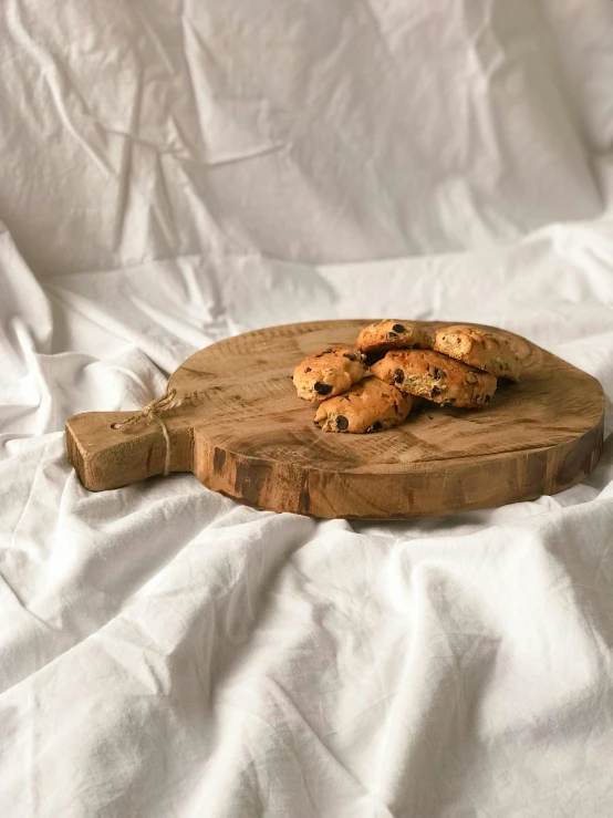 cookies sitting on top of a  board on top of white sheets