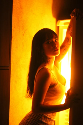 a woman holding a door handle in a dimly lit room