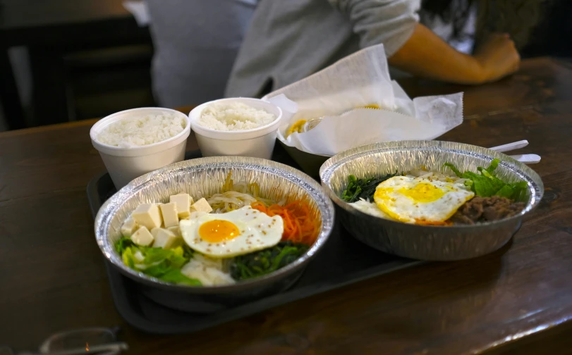 three trays with different foods on top of a table