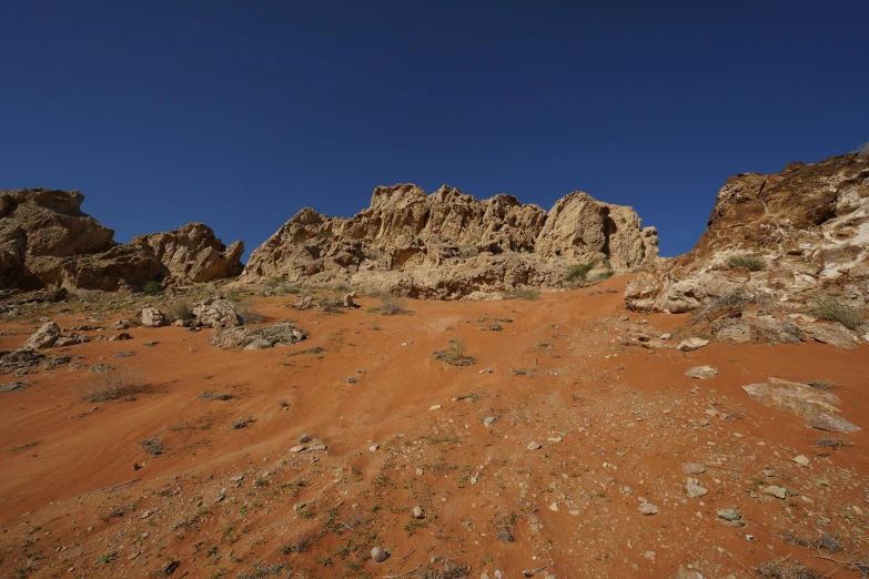 an arid plain with rocks in the background