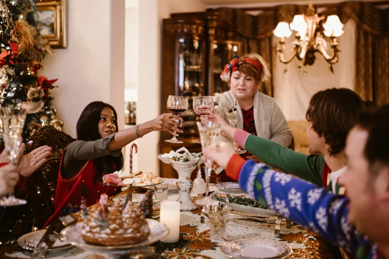 some women in christmas clothing raising champagne at a table