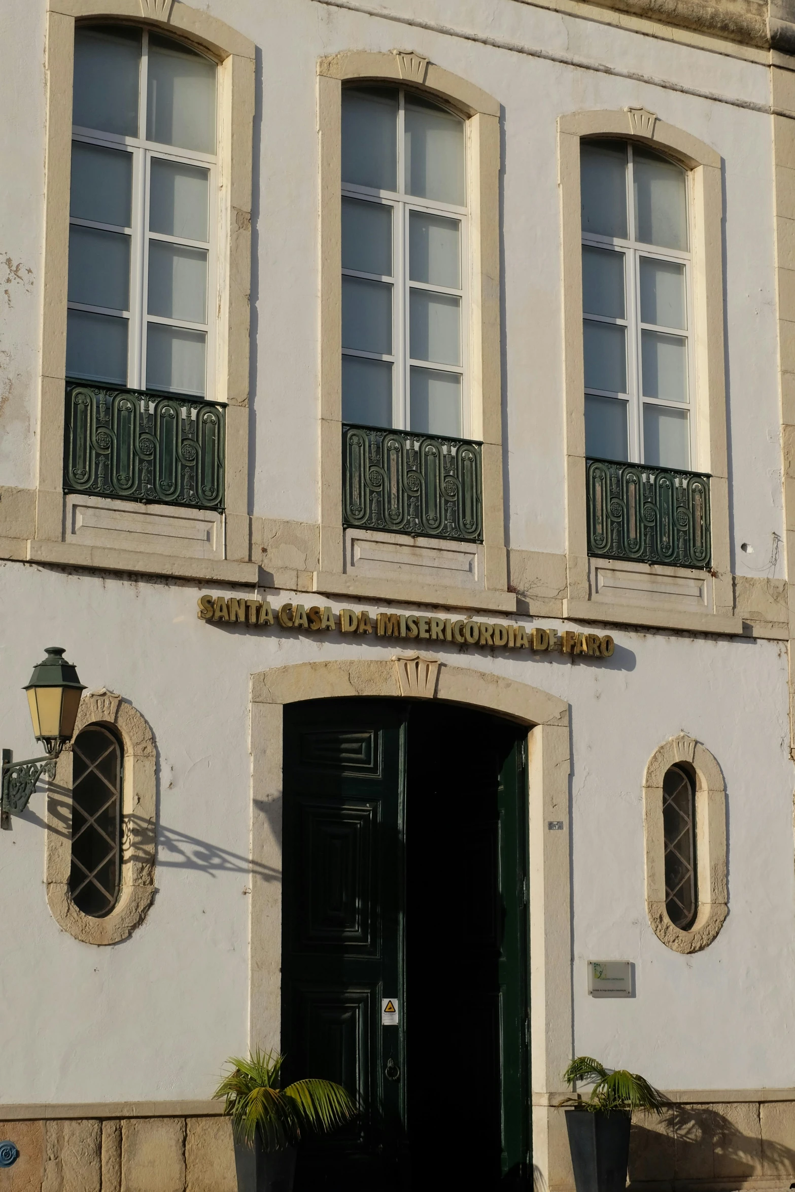 a white building with two black doors and a clock tower