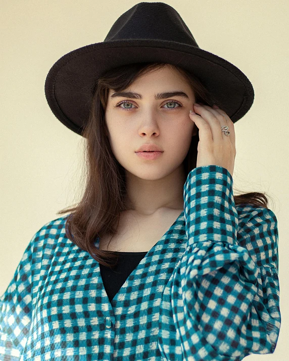 a girl with brown hair is wearing a black hat