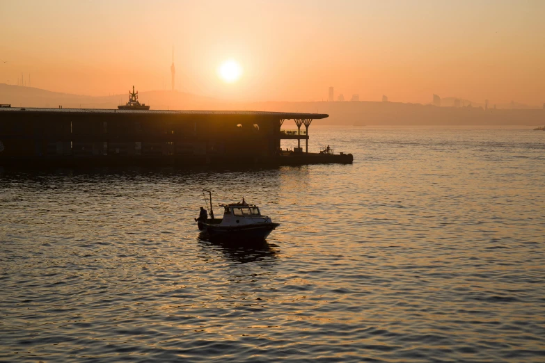 a boat is out on the ocean at sunset