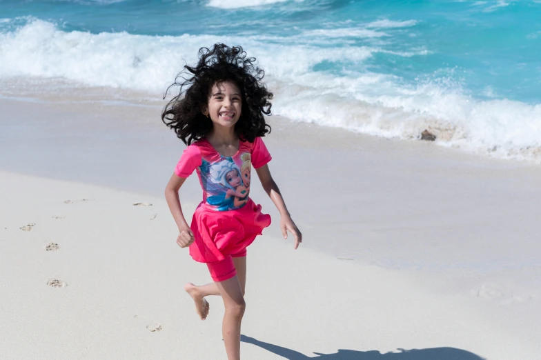 a child running on a beach next to the ocean