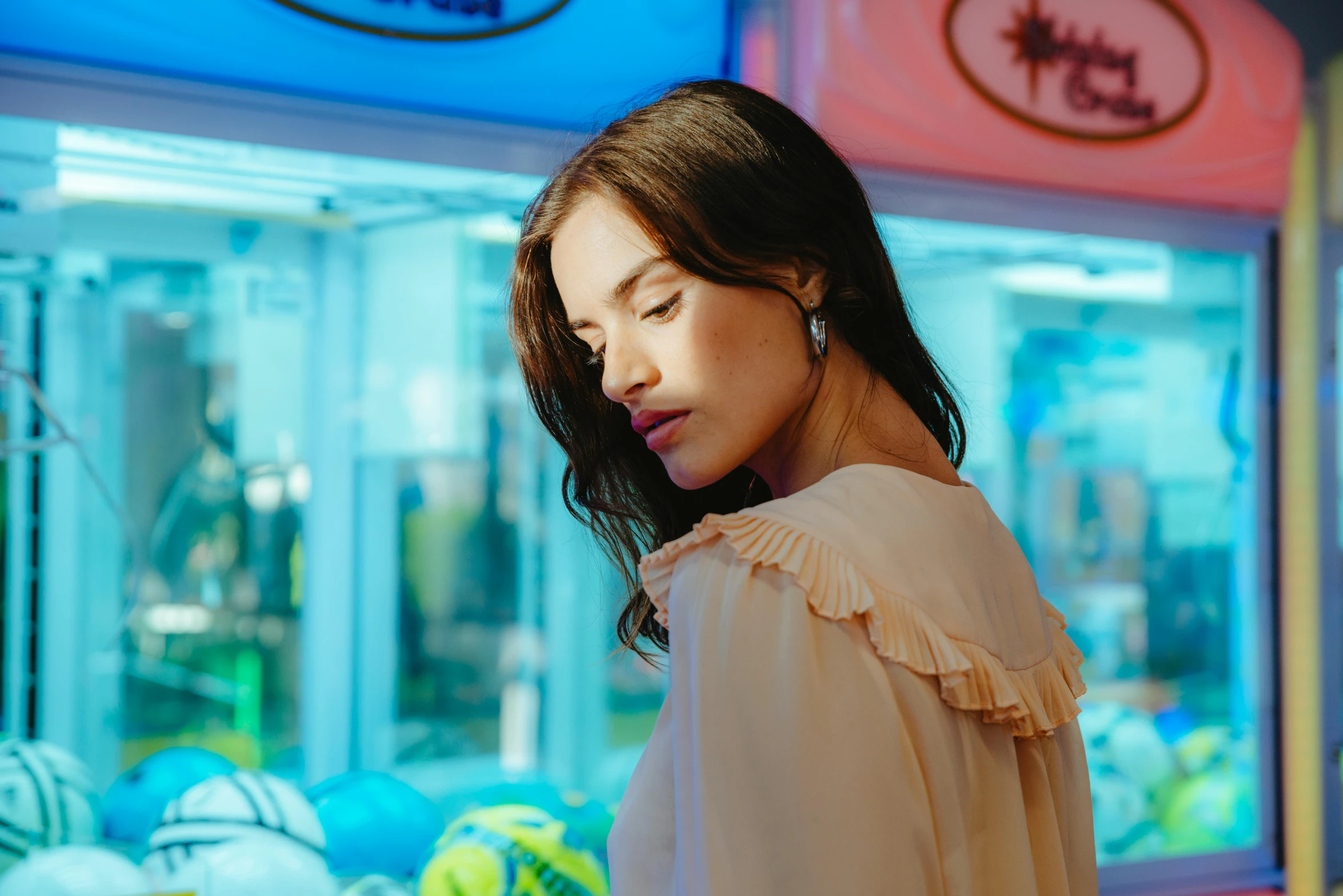 a woman wearing a blouse standing in front of a colorful store front