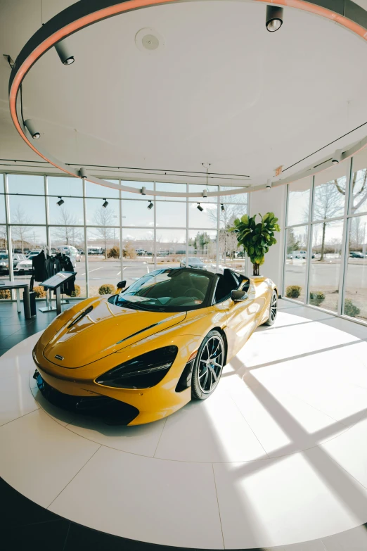 a beautiful orange sports car sitting inside of a garage